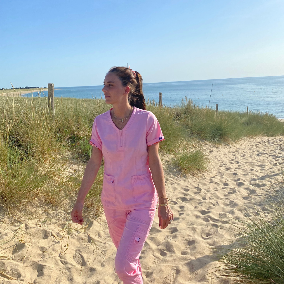 femme en blouse médicale rose sur la plage