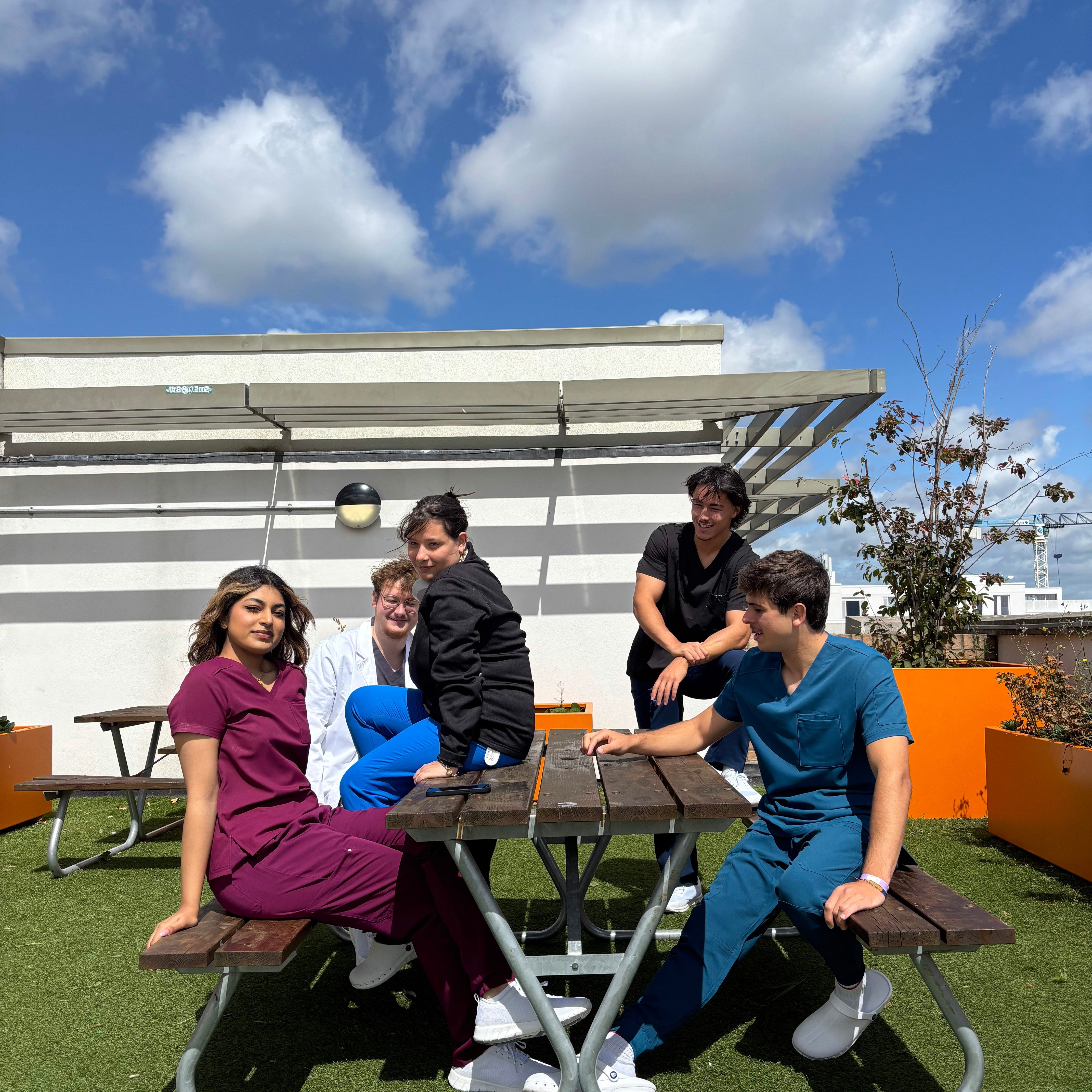Equipe médicale dentaire qui prend une pause au soleil sur une terasse portant des blouses Happyblouse
