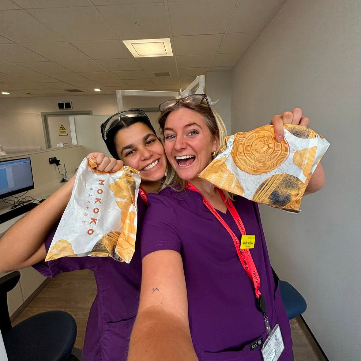 deux dentistes portant des tenues médicales violettes et se réjousissant de manger