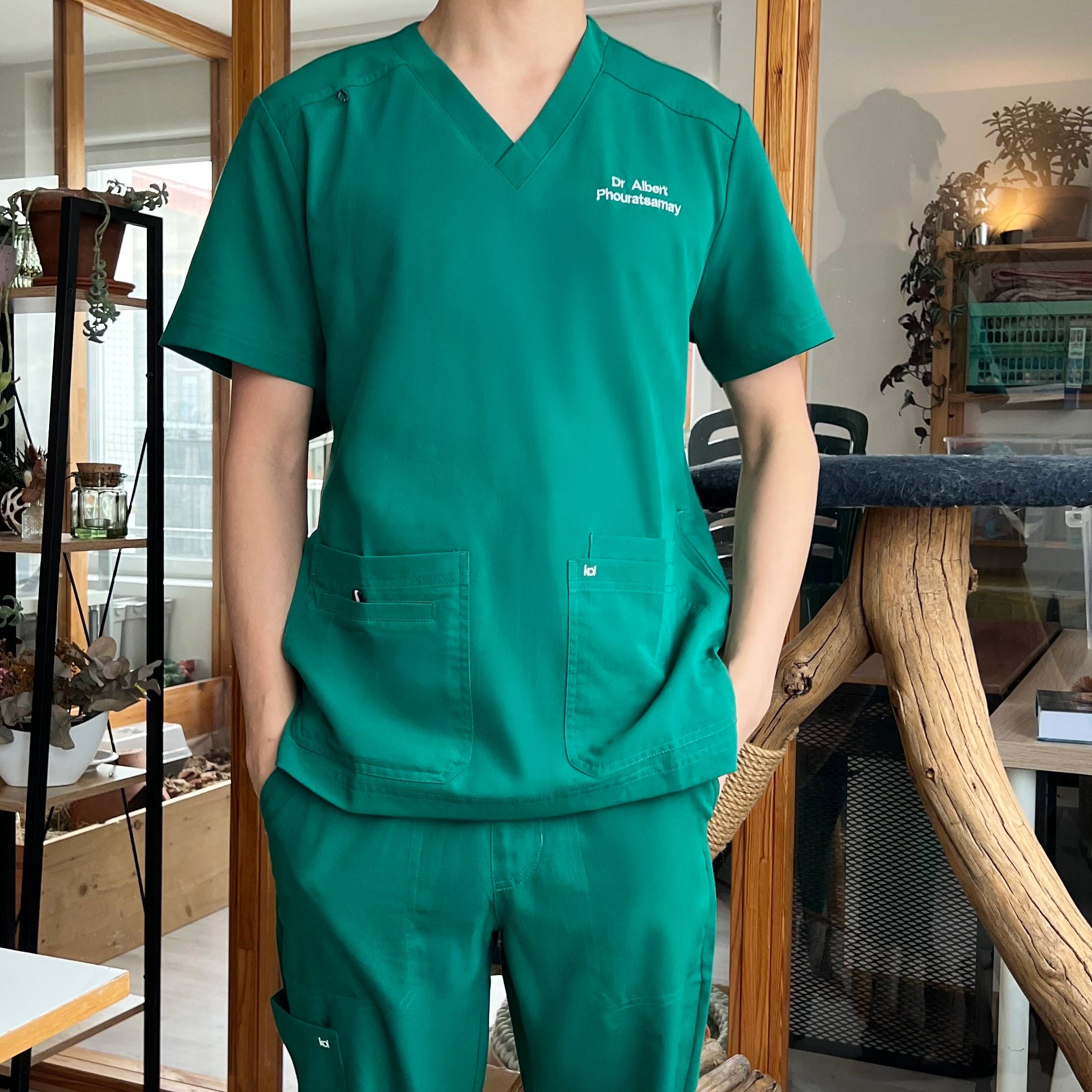 Vétérinaire portant une tenue Koi Next Gen de couleur verte et la marque Happyblouse