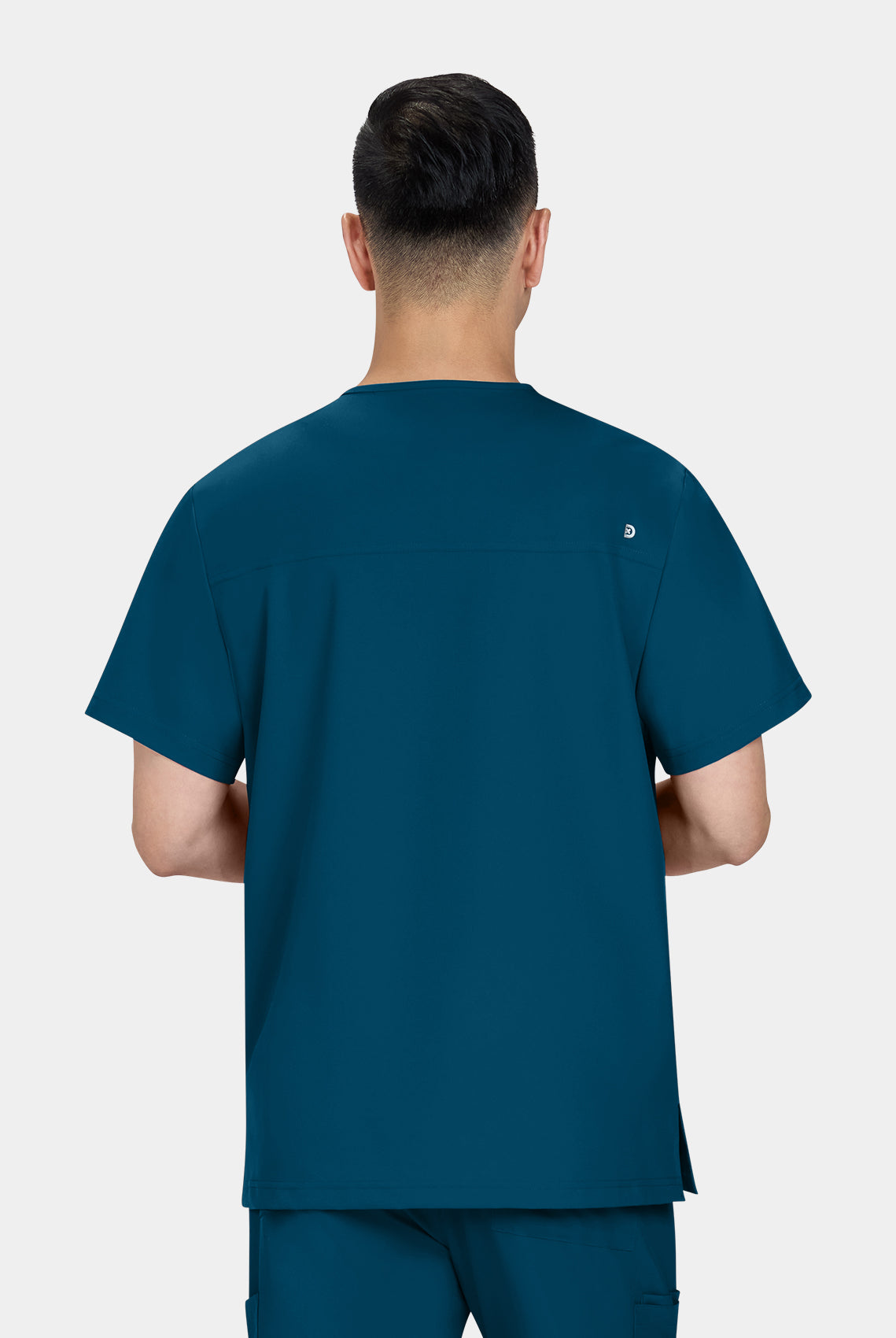 Homme de dos portant une blouse medicale Koi Cureology Stasis Bleu Caraibe