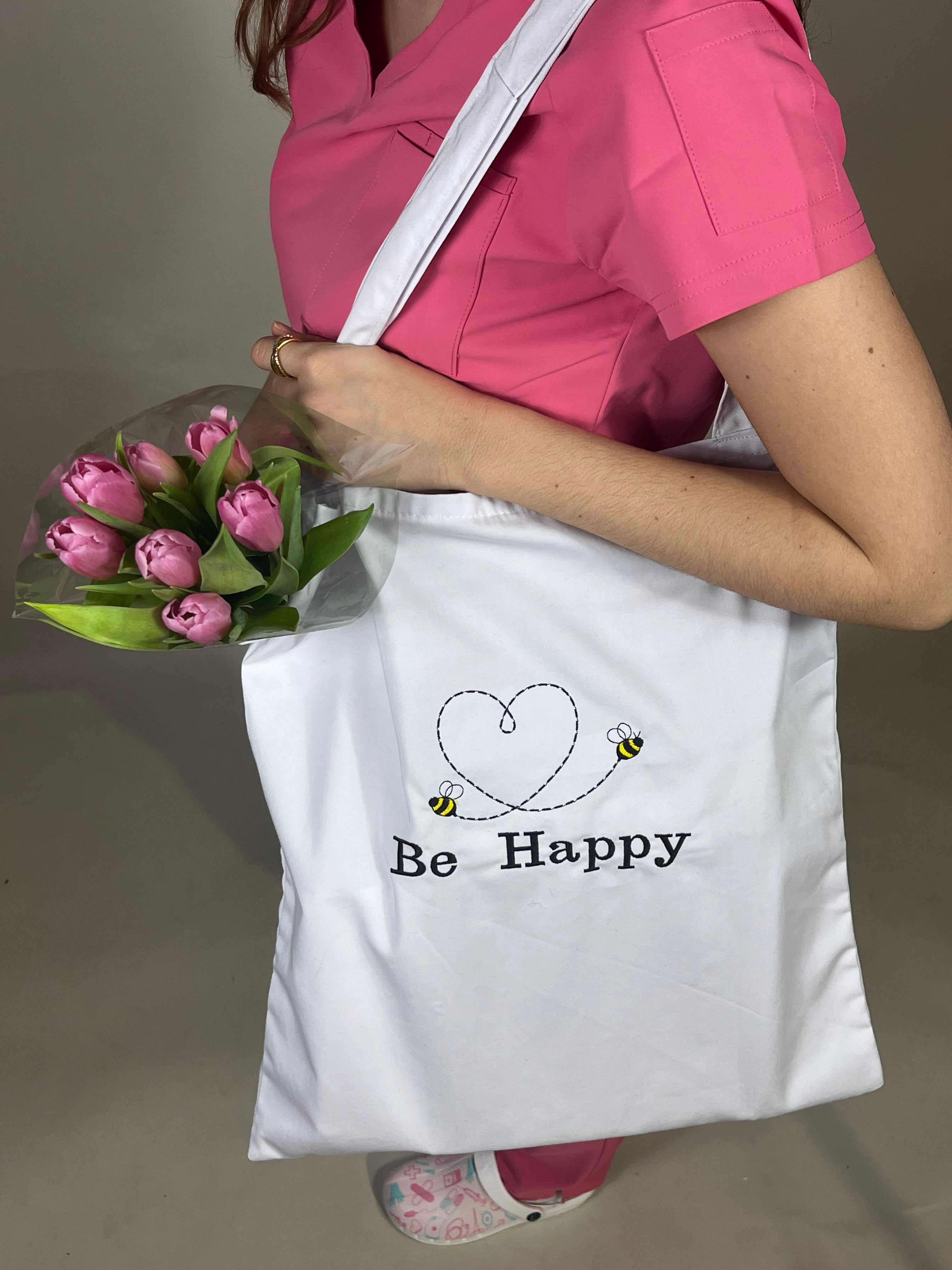 tote bag happyblouse koi blanc porté par une dentiste vétérinaire portant une blouse rose 