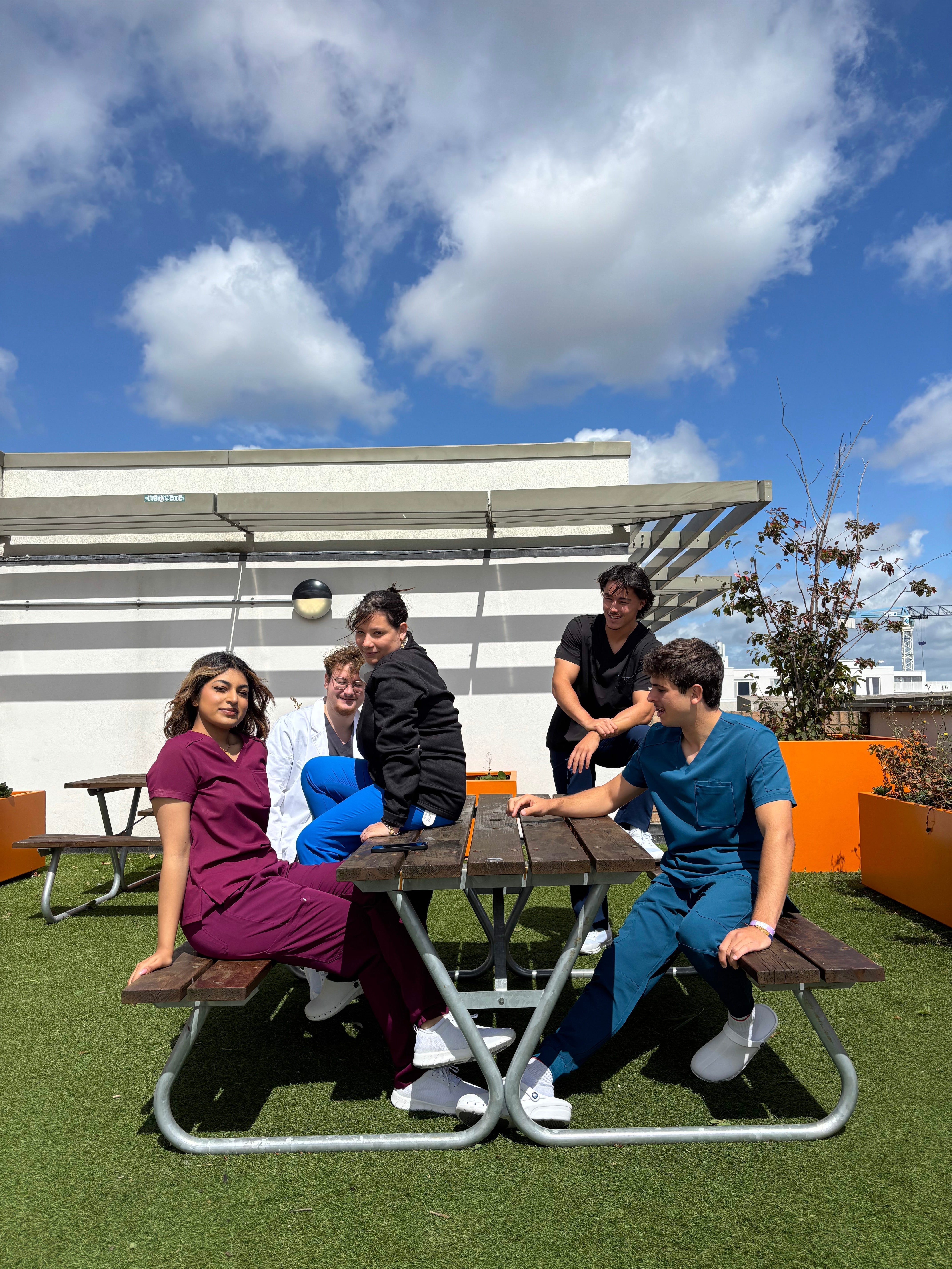 Equipe médicale dentaire qui prend une pause au soleil sur une terasse portant des blouses Happyblouse