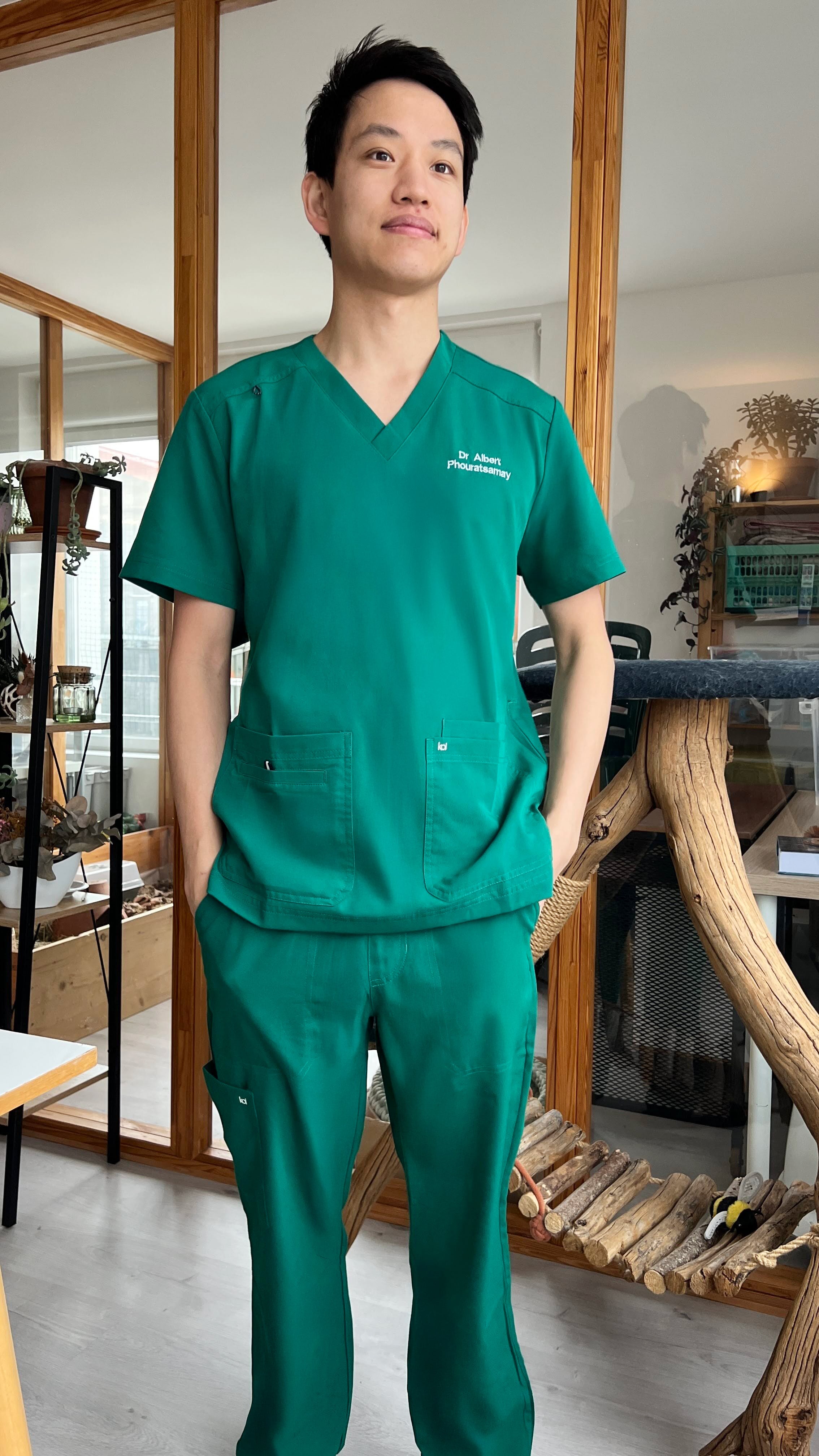 Vétérinaire portant une tenue Koi Next Gen de couleur verte et la marque Happyblouse