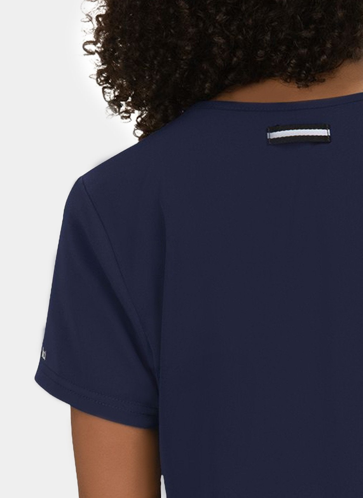 Blouse médicale femme Koi Next Gen Prête à travailler bleu marine - détail passant badge à l'épaule