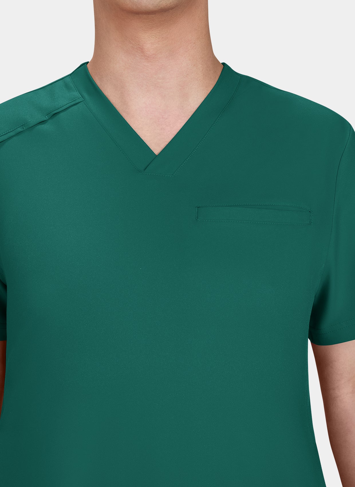 Zoom sur le torse d'un homme portant une blouse medicale koi cureology stasis vert foret 