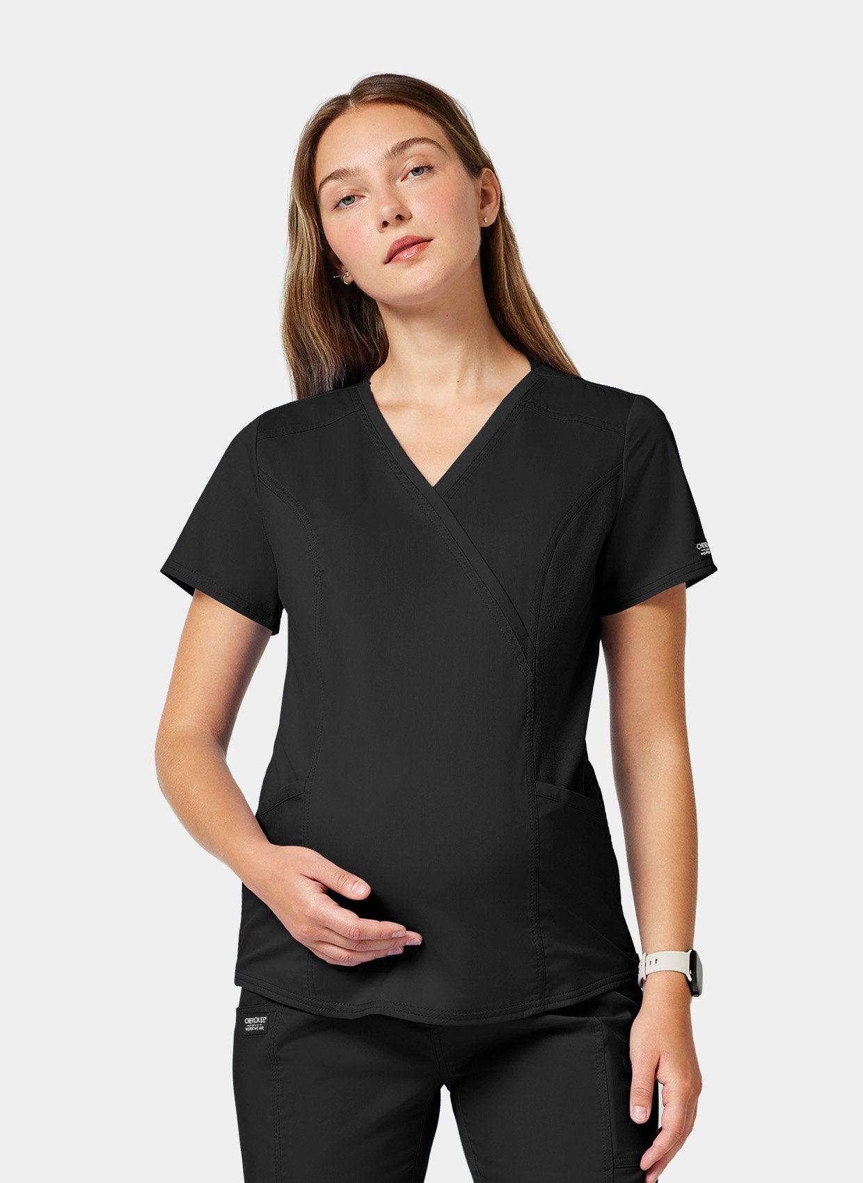 Blouse médicale noir femme face une main sur le ventre